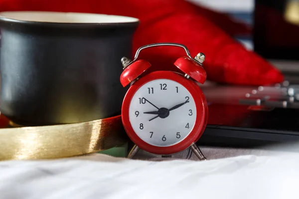 Kırmızı Alarm Saatini Bilgisayar Laptopunu Yatakta Bir Fincan Kahveyi Kapat — Stok fotoğraf