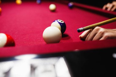 Boy plays billiard or pool in club. Young Kid learns to play snooker. Boy with billiard cue strikes the ball on table. Active Leisure, sport, hobby concept