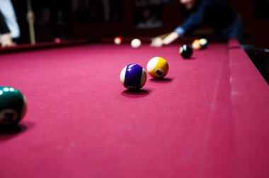 Boy plays billiard or pool in club. Young Kid learns to play snooker. Boy with billiard cue strikes the ball on table. Active Leisure, sport, hobby concept