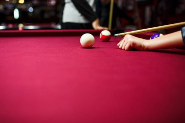 Boy plays billiard or pool in club. Young Kid learns to play snooker. Boy with billiard cue strikes the ball on table. Active Leisure, sport, hobby concept