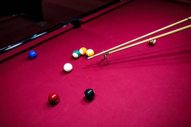 Boy plays billiard or pool in club. Young Kid learns to play snooker. Boy with billiard cue strikes the ball on table. Active Leisure, sport, hobby concept