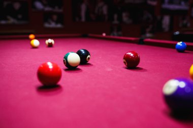 Boy plays billiard or pool in club. Young Kid learns to play snooker. Boy with billiard cue strikes the ball on table. Active Leisure, sport, hobby concept