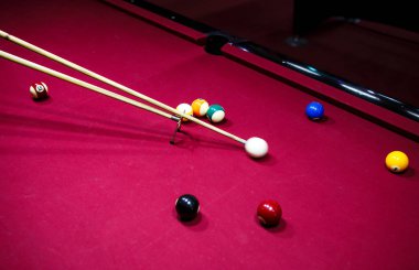Boy plays billiard or pool in club. Young Kid learns to play snooker. Boy with billiard cue strikes the ball on table. Active Leisure, sport, hobby concept