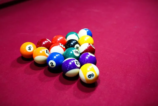 Billiard or pool balls lay on the red table in club. Snooker game. Active Leisure, sport, hobby concept