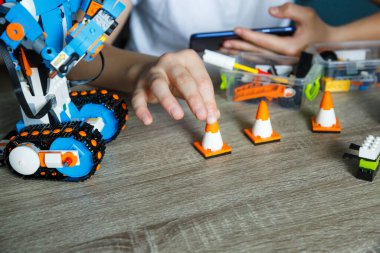 Kyiv, Ukrayna - 02, 09, 2020: Robot Lego Boost Vernie çocuğun ellerinde. Beyaz tişörtlü çocuk evde robot programlıyor. Öğrenci çocuk öğreniyor ve robotla oynuyor. Kök eğitim. Kapat.