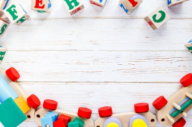 Çocuk oyuncakları: piramit, tahta bloklar, beyaz ahşap arka planda tren iskeleti. Eğitim, anaokulu oyunları. Üst Manzara. Düz yatıyordu. Metin için alanı kopyala