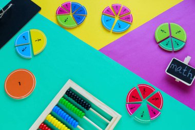 Matematikte yeşil, sarı ve mor arkaplanda renkli kesirler. Çocuklar için ilginç, eğlenceli matematik. Eğitim, okula dönüş konsepti.
