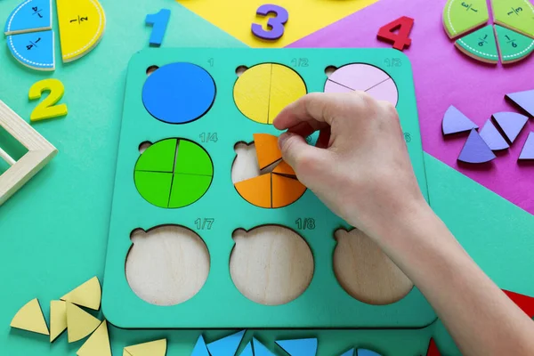 Kinderhand Bewegt Holzteile Von Bruchstücken Holzspielzeug Auf Buntem Papier Bildungsfraktionen — Stockfoto