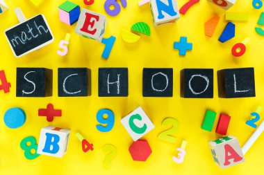 Sarı arka planda renkli matematik kesirleri. Masada unvan okulu olan bloklar. Çocuklar için ilginç, eğlenceli matematik. Eğitim, okula dönüş konsepti.