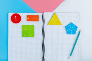 Renkli matematik kesirleri, mavi beyaz arka planda not defteri. Çocuklar için ilginç, eğlenceli matematik. Eğitim, okula dönüş konsepti.