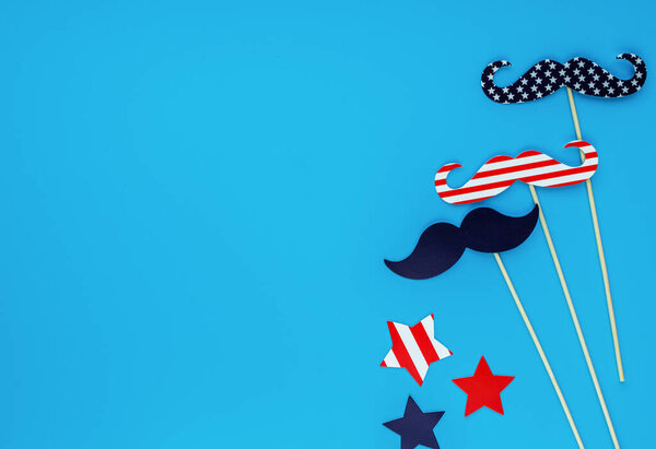 Decorations for 4th of July day of American independence, flag, candles, straws. USA holiday decorations on a wooden background, top view, flat lay