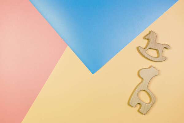 Симпатичные симпатичные маленькие деревянные детеныши с разными цветами на сине-желтом розовом фоне. Аксессуары для новорожденных. Плоский, вид сверху