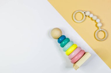 Sarı arka planda farklı şekillere sahip şirin, küçük tahta bebek bağcıklarını kapatın. Yeni doğan bebekler için eko aksesuarlar, bebeğim. Düz yatış, üst görünüm.