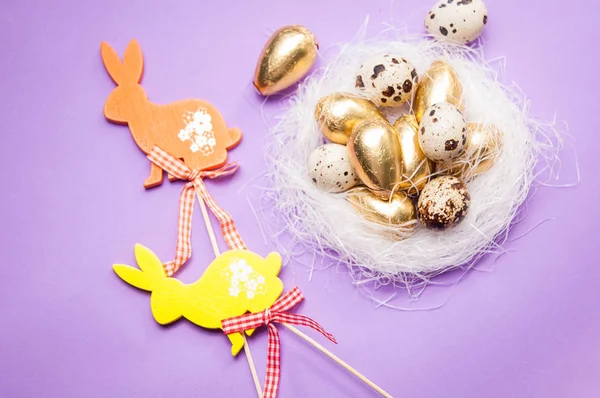 Easter bunnies and eggs on purple background — Stock Photo, Image