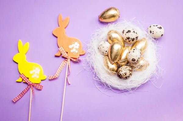 Easter bunnies and eggs on purple background — Stock Photo, Image
