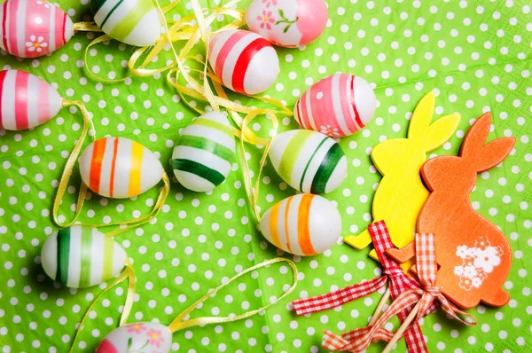 Easter bunny and eggs on green background — Stock Photo, Image