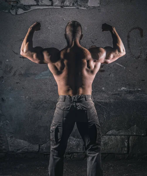 Bodybuilder sur mur de grunge — Photo