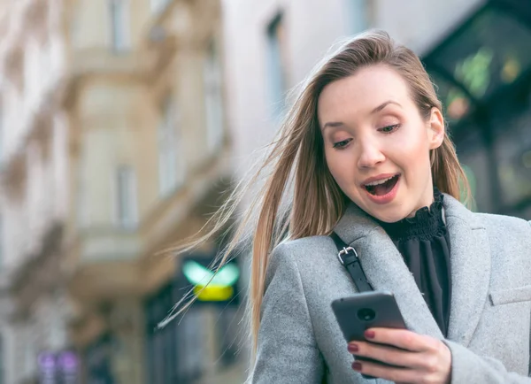 Žena stojící na ulici a pomocí mobilního telefonu — Stock fotografie