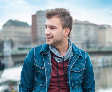 Yan görünümü şehir önünde genç adam portresi