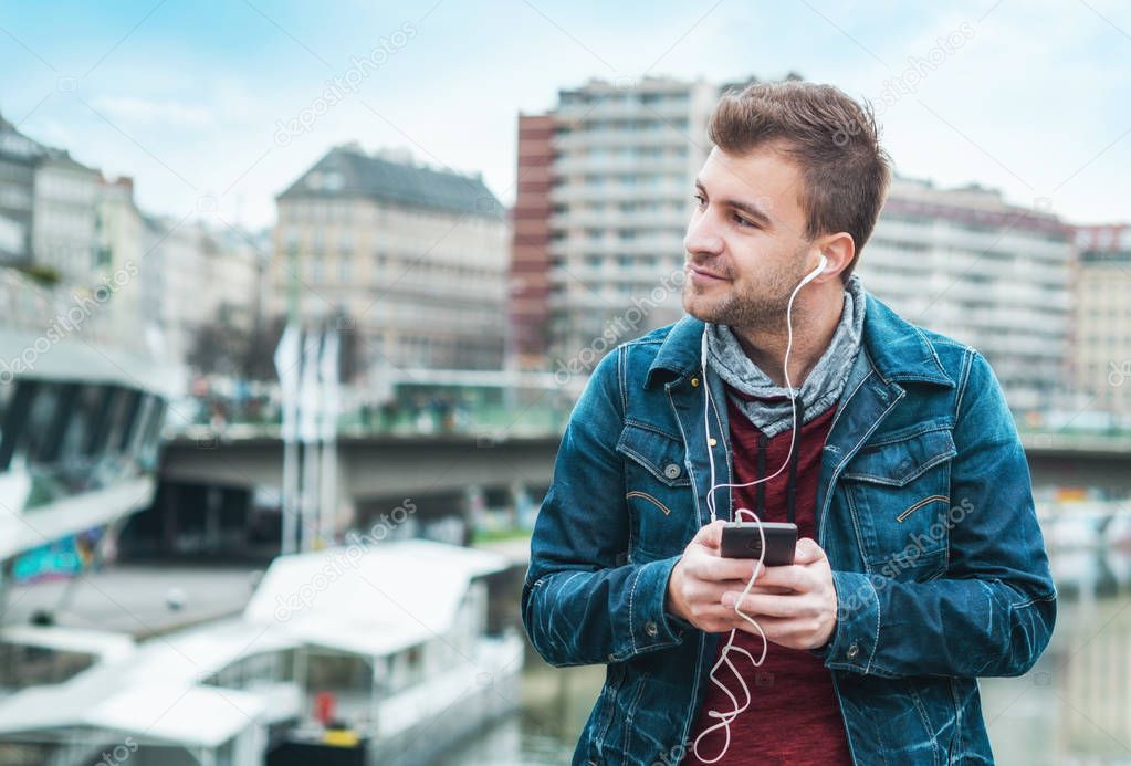 European man have fun time. Musical lifestyle. Cheerful stylish guy with smartphone listening music