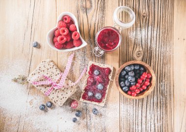 Tahta masanın üzerinde böğürtlenli tost ile tatlandırılmış. Lezzetli yemek, üst manzara.