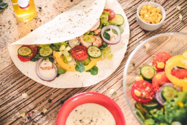 Tavuk ve sebzelerle sarılmış lezzetli tortillalar. Salata.