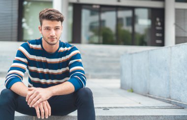 merdivenlerde oturan yakışıklı genç