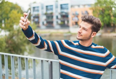 Happy man taking selfie in the city