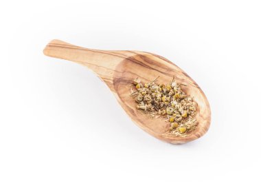 Kaşık üzerinde kurumuş papatya çayı yaprakları, beyaz grupta izole edilmiş.
