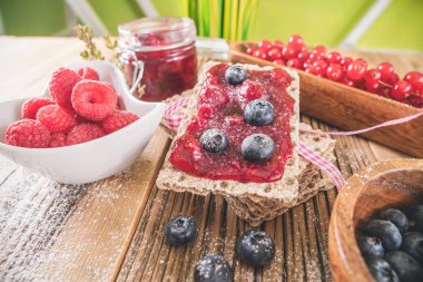 Hamur işi aperatifler ahşap masada servis edilen yaban mersinli tost ile reçel.