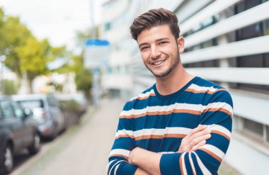 Belini kaldır ve mutlu genç adam gülümse. Şehrin dışındaki kameralara gülümse.