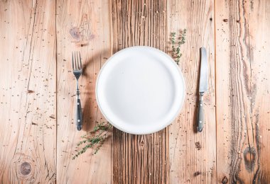 Tahta masada boş beyaz tabak. Yemek daveti. Servis yapmaya ve taze yemek pişirmeye hazır. Metin ya da ürün için boşluk. Üst görünüm - düz uzanma