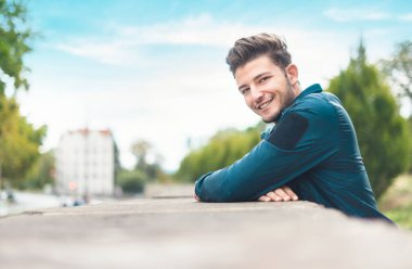 Şehrin sığ dof mutlu genç adam. Ceket giyen adam gülümse. Açık havada, kopya alanı