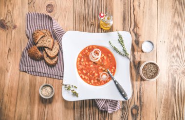 Ekmek, peçete ve kaşıkla bir kase fasulye çorbası servis ettim. Üst görünüm - genel veya yukarıdan görünüm