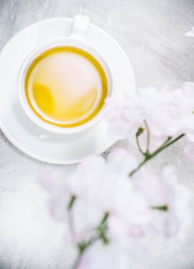 Yeşil Japon çaylı Asya çay fincanı. Çiçek açan dallar gri masanın etrafında. Üst Görünüm - Yukarıda