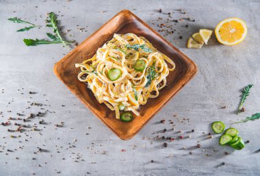 Ekşi limonlu ve otlu makarna, gri arka planda izole edilmiş. Üst yaşam
