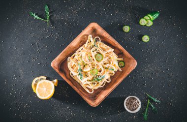 Ekşi limonlu ve otlu makarna, gri üzerine izole edilmiş - siyah arka plan. Üst yaşam