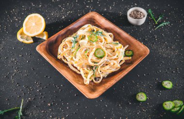 Ekşi limonlu ve otlu makarna, gri üzerine izole edilmiş - siyah arka plan. Üst yaşam