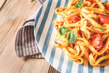 Tabakta domates soslu makarna. Lezzetli tagliatelle öğle yemeği - yemek. Kapat.