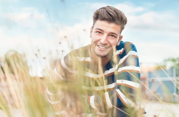 Bulanık Çimenlerin Arasından Kameraya Gülümseyen Güzel Bir Adam Seçici Bir — Stok fotoğraf