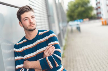 Modern ve sıradan. Yakışıklı genç adam dışarı, dışarı, yana bakıyor.