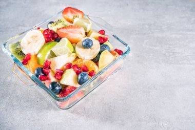 Gri yüzeyde bir kasede meyve salatası ve fotokopi odası manzarası