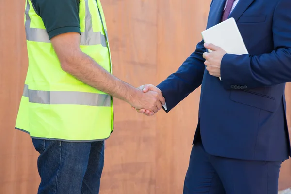 Empresario agitando las manos con constructor en el sitio de construcción — Foto de Stock