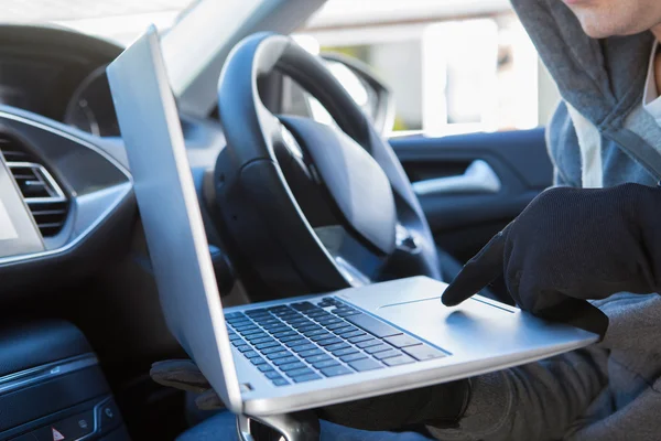 Κλέφτης χρησιμοποιώντας το φορητό υπολογιστή σε σιδηροπρίονο σε λογισμικό ασφάλειας αυτοκινήτου — Φωτογραφία Αρχείου