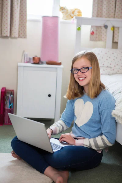 Porträt eines Mädchens, das mit Laptop auf dem Boden des Schlafzimmers sitzt — Stockfoto