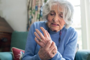 Senior Woman At Home Suffering With Arthritis clipart