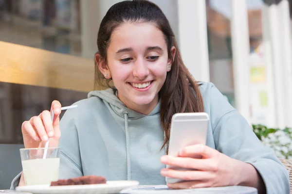 Tânără fată la Cafe Reading Mesaj text pe telefonul mobil — Fotografie, imagine de stoc