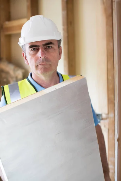 Portrait Of Builder Fitting Insulation Boards Into Roof Of New H — Stock Photo, Image