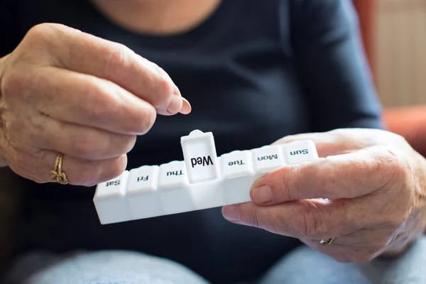 Seniorin nimmt Medikamente aus Tablettenbox — Stockfoto