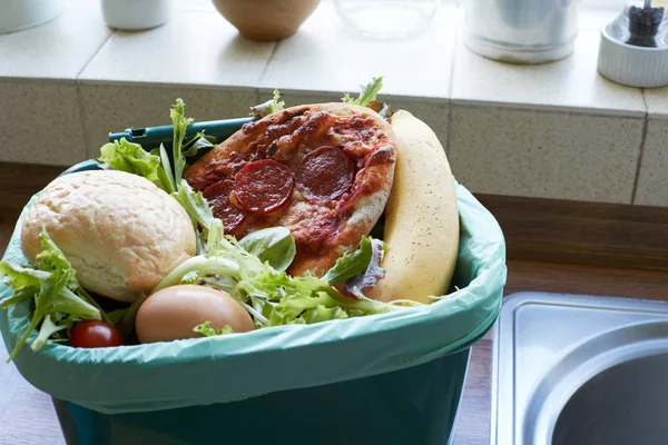 Residuos de alimentos frescos en la papelera de reciclaje en casa — Foto de Stock